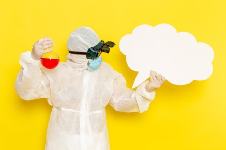 front-view-male-scientific-worker-special-protective-suit-holding-flask-with-red-solution-big-white-sign-yellow-desk_140725-64046.jpg
